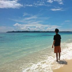 Rear view of woman standing on beach