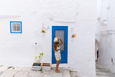 Rear view of woman standing against door