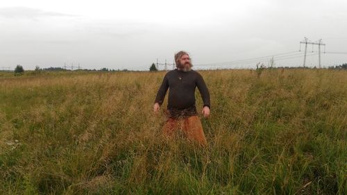 Full length of man standing on field against sky