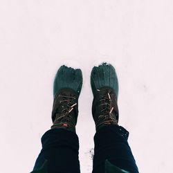 Low section of person standing on snow covered land