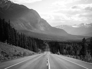 Empty road along landscape and mountains against sky