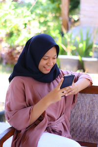 Woman sitting on mobile phone