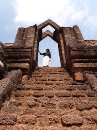 Woman standing at entrance of historical building