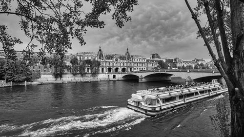 Boats in river. the louvre palace is visible with the esine river in paris