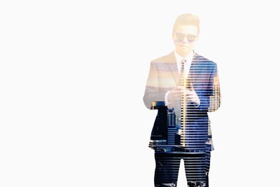 Digital composite image of man holding smart phone against white background