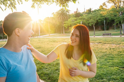 Portrait of smiling friends standing against trees