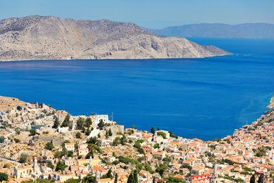 Scenic view of town by sea against sky