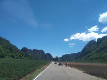 Road amidst green landscape against sky