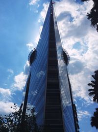 Low angle view of modern building against cloudy sky