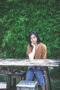 Portrait of a smiling young woman sitting on table