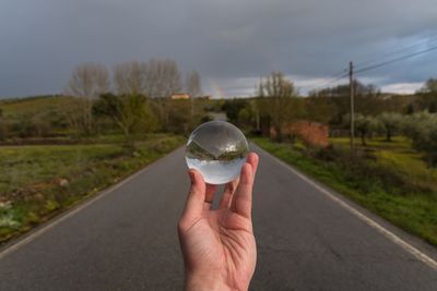 Person holding umbrella on road