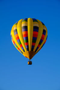 Low angle view of hot air balloon against clear blue sky