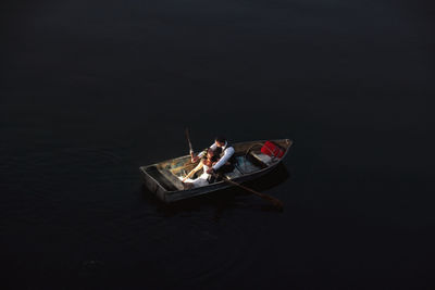 High angle view of people on boat against black background