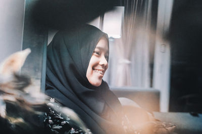 Portrait of a smiling young woman sitting at home