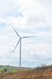 Windmill on field against sky