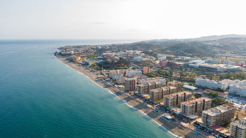 High angle view of townscape by sea against sky