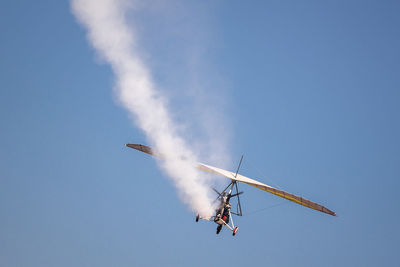 Low angle view of airplane flying against sky