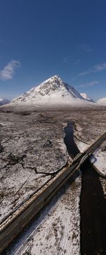 Scenic view of snowcapped mountains against blue sky