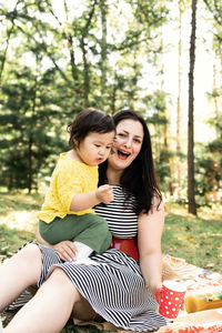 Happy young woman sitting on tree