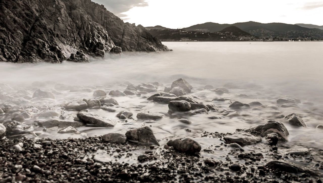 water, mountain, scenics, tranquil scene, beauty in nature, tranquility, sea, nature, rock - object, mountain range, sky, idyllic, beach, lake, shore, non-urban scene, rock formation, coastline, remote, no people