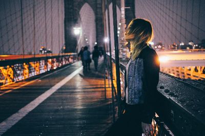 Woman walking on railroad station platform at night