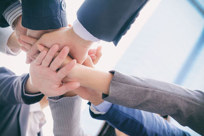 Cropped image of business people stacking hands at office