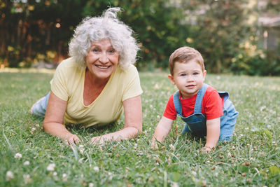 Grandmother playing with grandson on grass at park