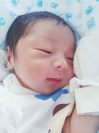 Close-up of baby sleeping on bed