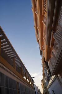 Low angle view of buildings against clear blue sky