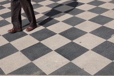 Low section of woman walking on tiled floor