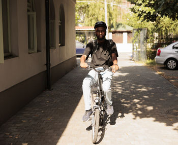 Side view of man riding bicycle on street