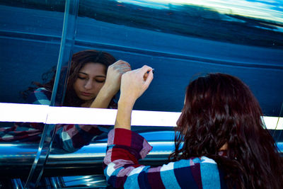 Reflection of young woman on vehicle