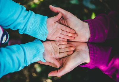 Directly above shot of mother and child hands playing outdoors