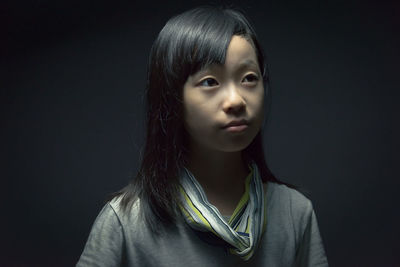 Close-up of girl against black background