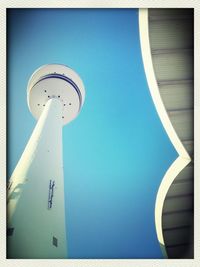 Low angle view of communications tower against blue sky