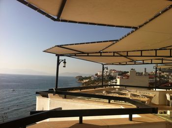 Scenic view of sea by building against clear sky