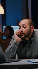 Side view of young man using mobile phone at office