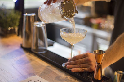 Close-up of hand holding wine glass on table