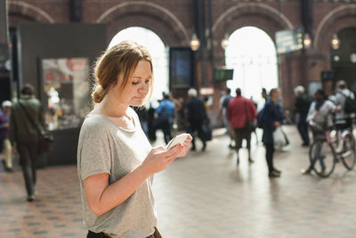 Woman using mobile phone in city