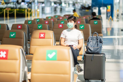 Midsection of woman sitting at airport