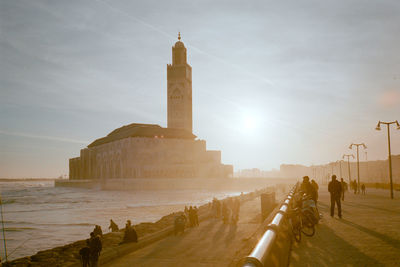 People on historical building against sky