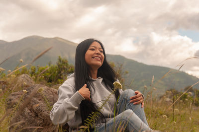 Portrait of young woman sitting on mountain