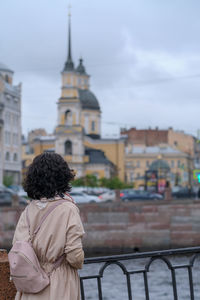 Rear view of woman looking at buildings in city