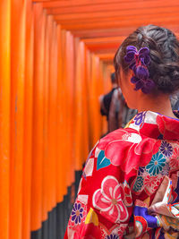 Rear view of woman standing in temple