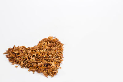 Close-up of dried cake against white background