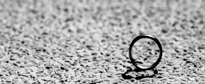 Close-up of wedding ring on beach