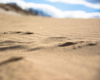 Surface level of sand dunes against sky