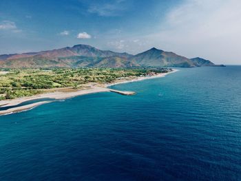 Scenic view of sea and mountains against sky