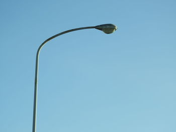 Low angle view of street light against blue sky