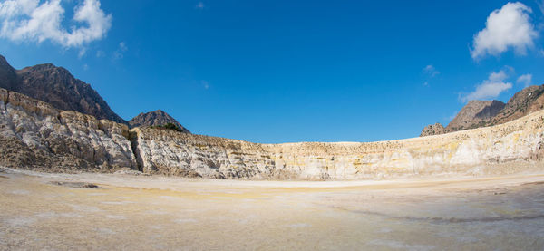 Panoramic view of rock formations against blue sky